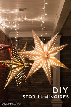 some lights that are hanging from the ceiling in front of a brick wall and two large stars