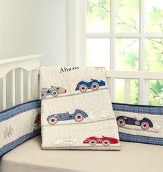 two baby crib sets with cars on them, one is blue and the other is white