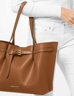 The coveted Emilia tote bag showcases a belted silhouette that will add a sleek sophistication to your wardrobe.Pebbled leather100% leather from tanneries meeting the highest standards of environmental performance 16.75”W X 11.5”H X 8.5”DHandle drop: 11.25”Compatible with 13” laptopInterior details: back zip pocket, center zip compartment, 6 front slip pocketsLining: 100% polyesterSnap fasteningColor: Luggage Leather Tote Bag, Luggage Bags, Pebbled Leather, Leather Tote, Zip Pockets, Michael Kors, Sleek, Tote Bag, Wardrobe