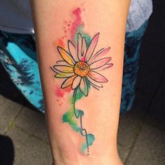 a woman's arm with a watercolor flower tattoo on the left side of her body