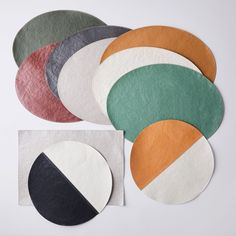 six circular coasters in different colors and sizes on a white surface with one circle cut out