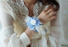 a woman is wearing a white and blue corsage