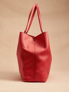 Wider than it is tall, this East-West tote fits most laptops up to 15" and is crafted in luxe leather with a special zip pocket for small items.  Snap closure.  Interior zip pocket.  Unlined.  Height: 14. 7" (37cm) Width: 21. 25" (54cm) Depth: 5. 5" Large Modern Satchel For Travel, Large Modern Travel Satchel, Modern Large Travel Satchel, Large Leather Modern Satchel, Large Modern Leather Satchel, Modern Soft Leather Tote Laptop Bag, Modern Large Travel Shoulder Bag, Large Leather Bag For On-the-go, Red Leather Travel Laptop Bag