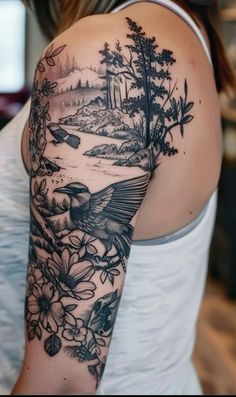 a woman with a bird and flowers tattoo on her arm