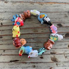 a bracelet made out of glass animals on a wooden surface