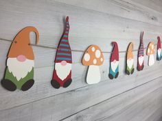 colorful gnomes are hanging on the side of a wall