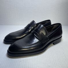 Elevate your style with these sleek black leather slip-on loafers from Bruno Magli. The Hudson model features a solid pattern with a round toe and a slip-on closure for easy wear. These dress shoes are perfect for any occasion and will add a touch of sophistication to any outfit. Crafted in Italy, these shoes boast a high-quality leather upper, lining, and insole for ultimate comfort. The outsole is also made of leather for durability and style. The shoes come in a men's size 7.5 and are perfect for those who want to make a stylish statement without compromising on comfort. Luxury Black Slip-on Leather Shoes, Masculine Black Slip-on Dress Shoes, Masculine Slip-on Formal Loafers, Masculine Leather Slip-on Loafers, Luxury Masculine Slip-on Loafers, Penny Loafers Men, Bruno Magli, Model Features, Solid Pattern