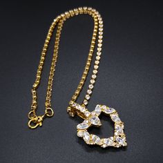 *Description: This is a beautiful Monet gold plated rhinestone necklace with a clear rhinestone heart pendant from the 1970s. The beautiful pendant has rhinestones in chaton and marquise cut clear crystals. The chain is very unique for Monet with the entire chain rhinestone links and a sister clasp. The clasp has MONET on one side and PAT PEND on the other. This is a beautiful necklace for someone special in your life. This would be a great addition to your vintage jewelry collection or make a g Vintage Rhinestone Necklace With Chain For Gift, Vintage Gold Rhinestone Necklace With Sparkle, Vintage Pendant Necklace With Rhinestones, Vintage Gold Metal Rhinestone Necklace, Vintage Rhinestone Adjustable Necklace, Poison Ring, Rhinestone Heart, Rhinestone Necklace, Screw Back Earrings