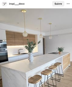 a kitchen island with four stools in front of it and an open floor plan