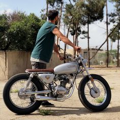 a man riding on the back of a silver motorcycle