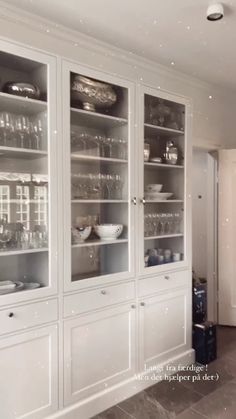 a large white china cabinet with glass doors