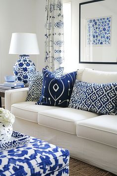 a living room filled with blue and white furniture