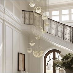 a large chandelier hanging from the ceiling in a room with white walls and windows