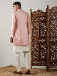 Vastramay Men's Peach Sequined Indo Western Sherwani With Kurta Pyjama Set Make a statement at weddings and festive occasions with this elegant Indo Western Sherwani set from VASTRAMAY. Crafted in a peach hue with sequin detailing, this outfit exudes traditional charm with a modern twist. The set includes a Sherwani and matching Kurta Pyjama. Features: Sequined detailing for a stylish look Modern Indo Western design Includes Sherwani and Kurta Pyjama Perfect for weddings and festive occasions Sp Pink Nehru Jacket For Diwali With Traditional Drape, Pink Sherwani With Cutdana For Designer Wear, Designer Pink Sherwani With Cutdana, Pink Long Sleeve Bandhgala With Cutdana, Pink Nehru Jacket Straight Kurta For Diwali, Pink Nehru Jacket For Diwali, Eid Pink Raw Silk Sherwani, Pink Dabka Sherwani For Eid, Bollywood Style Pink Nehru Jacket For Eid