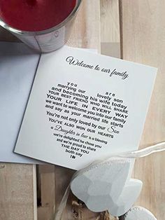 an open book with a note attached to it next to a cup of tea and a candle