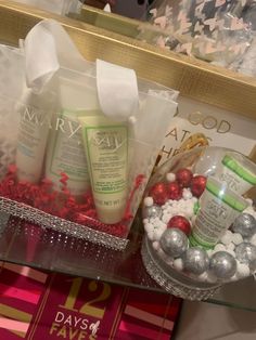 the contents of a holiday gift basket are displayed in front of a gold tray with red and silver ornaments