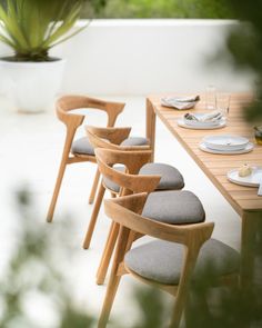 a table with four chairs and plates on it