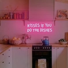 a pink neon sign that says kisses if you do the dishes in a kitchen with white cabinets