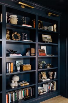 a bookshelf filled with lots of books in a room