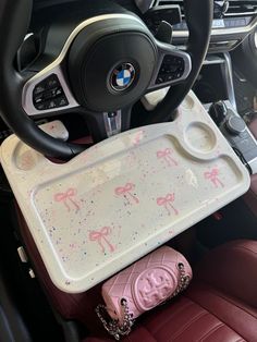 the interior of a bmw car with pink and white decorations on it's tray