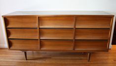 a large wooden dresser sitting on top of a hard wood floor next to a wall