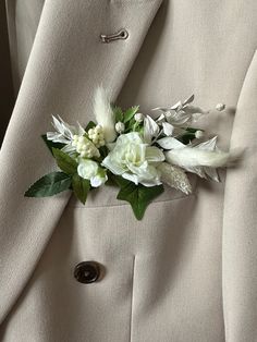 a close up of a suit with flowers on it's lapel flower pin