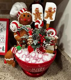 a red bowl filled with lots of christmas decorations next to a sign that says merry