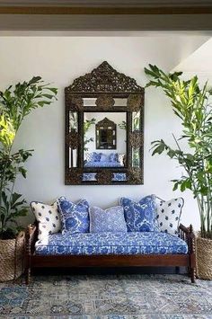 a living room with couches, mirrors and potted plants