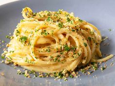 a blue plate topped with pasta and parmesan sprinkled on top of it