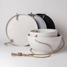 white bowls with rope around them are stacked on top of each other