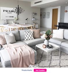 a living room filled with lots of furniture next to a white table and couches