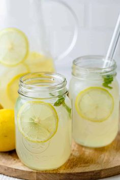 two mason jars filled with lemonade on a cutting board