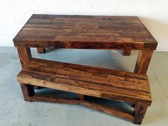 a wooden bench sitting on top of a cement floor