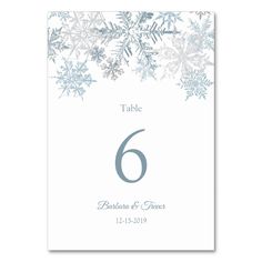 a table number with snowflakes on it and the number six is in blue