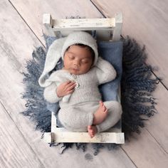 a newborn baby is sleeping in a wooden crate