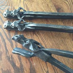 some metal tools are laying on a wooden table