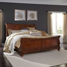 a large bed sitting on top of a hard wood floor next to a white rug