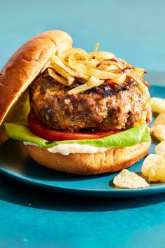 a hamburger and chips on a blue plate