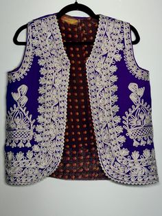 Made in Afghanistan, this a rare find vintage sleeveless waistcoat. Hand embroidery on velvet. A very antique piece in mint condition.  Measurements in inches (Flat): Shoulder: 14 Bust: 19 Length: 22.5 Note: Worn and minor signs of wear. Bohemian Sleeveless Vest For Festivals, Folk Style Sleeveless Festival Vest, Festive Bohemian Sleeveless Vest, Sleeveless Wedding Vest For Festivals, Traditional Embroidered Fitted Vest, Traditional Fitted Vest With Intricate Embroidery, Fitted Traditional Vest With Intricate Embroidery, Fitted Embroidered Traditional Vest, Traditional Vest With Floral Embroidery For Festival