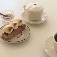 there is a piece of pie on the plate with marshmallows and a cup of coffee