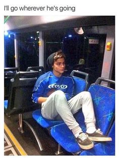 a man sitting on a bus with his legs crossed