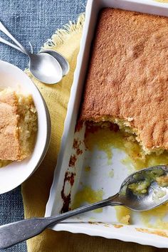 a piece of cake in a dish with a spoon next to it on a table