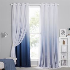 a bedroom with blue and white curtains in the window