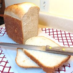 a loaf of bread sitting on top of a white plate with a knife next to it