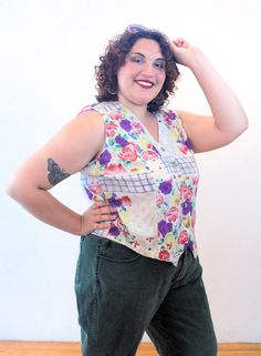 This is a very cute 90s boho floral vest by Passports of Pier 1 Imports! It's a lightweight, breezy gauze rayon vest that could also be worn as a sleeveless top. It has a painterly flower print in purple, dusty rose pink, yellow and green, with a blue windowpane design on a beige background. It has a lapped V neck, generously cut arm holes, a hem that comes to two points in the front, and it closes with five marbled tan front buttons.The vest is in good clean condition, no flaws noted. The label Floral Vest, 90s Boho, Floral Vests, 90s Floral, Pier 1 Imports, Beige Background, Pier 1, Boho Floral, Rose Pink