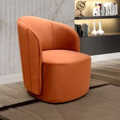 an orange chair sitting on top of a rug in front of a bookshelf