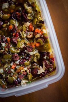 a plastic container filled with food on top of a wooden table