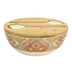 a wooden bowl with an ornate design on the side and two spoons in it