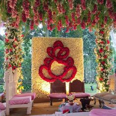 an outdoor wedding setup with flowers on the wall