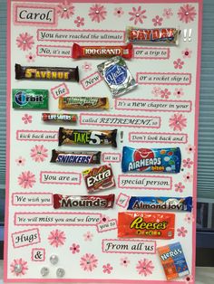 a candy bar display with pink flowers on the front and bottom, filled with candy bars